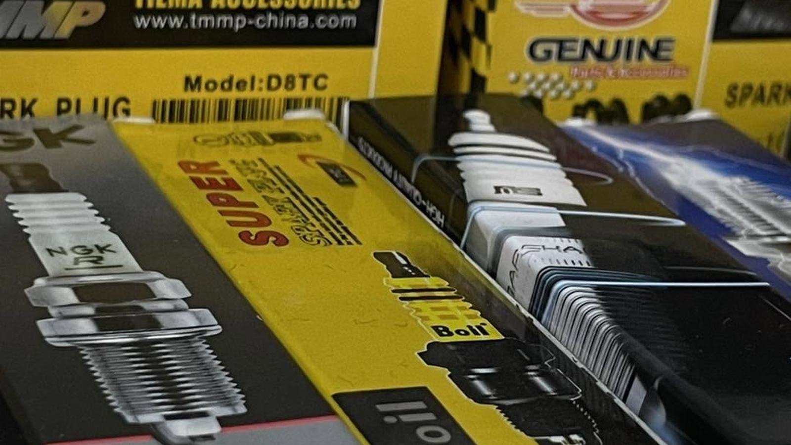 NGK and other motorcycle spark plugs in boxes